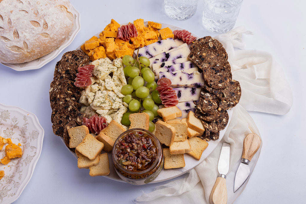 Cheese board with grapes, berries and assorted cheeses